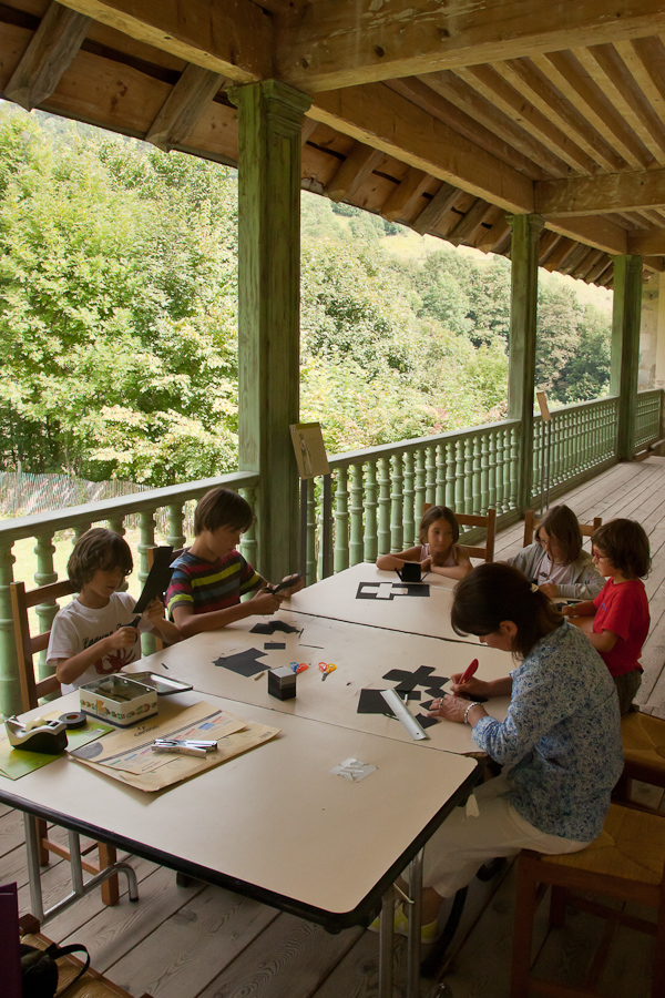 Enfants et adultes s'appliquent pour la construction du boîtier en carton du sténopé.